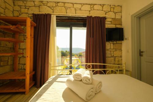 una camera da letto con un letto con asciugamani sopra di Kybele Alaçatı a Smirne