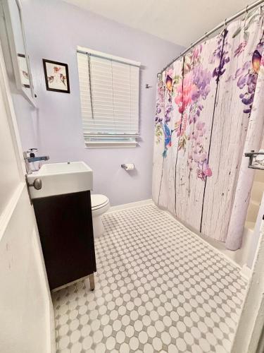 a bathroom with a toilet and a shower curtain at Blue Birdhouse - Indiana Dunes - Pet Friendly in Chesterton