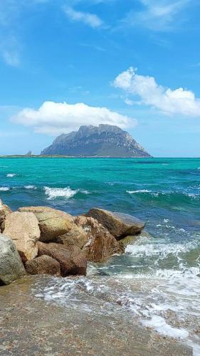 a mountain in the ocean with rocks in the water at Porto San Paolo a 50 mt dal mare in Porto San Paolo