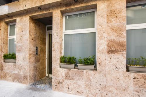 a facade of a building with windows with potted plants at 51HH Apartments in Il-Gżira