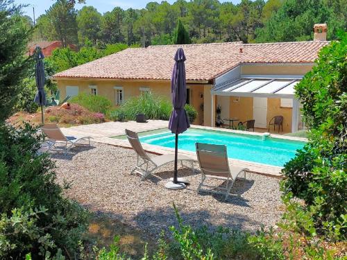 - une piscine avec des chaises et des parasols en face d'une maison dans l'établissement Ô fil du THYM, à Sillans-la-Cascade