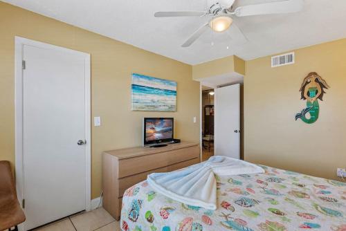a bedroom with a bed and a flat screen tv at Waves 14 Condo Beautiful 1 Bedroom with Pool in St Pete Beach