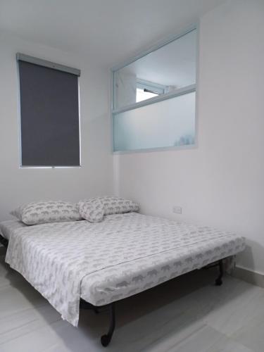 a bed in a white room with a mirror at Black & White Comfort Studio in San Juan