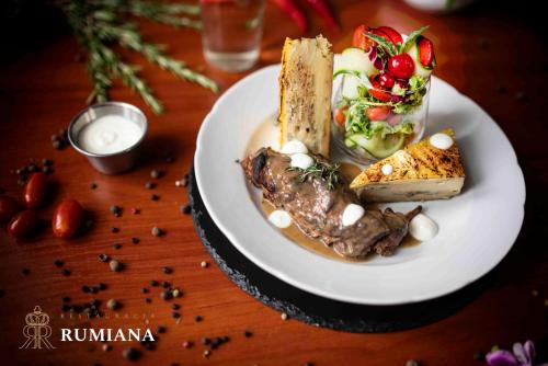 a plate of food with meat and vegetables on a table at Hotel Diamond w Białym Dworku in Rumia