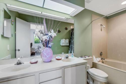 a bathroom with a sink and a toilet and a mirror at St Pete Isla Vista Verde E 3 219 Corner Unit 2 2 in Point Brittany