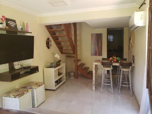 un soggiorno con cucina e un bar con sgabelli di Triplex 3 Suítes 10 PESSOAS Cond Aldeia dos Pescadores Praia do Forte a Praia do Forte