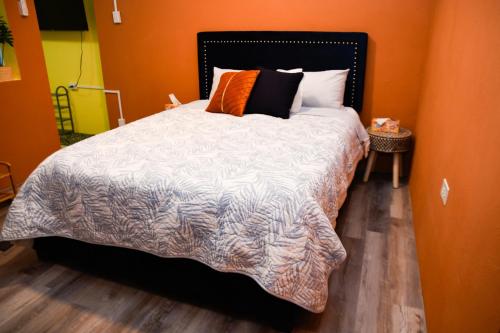 a bedroom with a large bed with an orange wall at One Bedroom Apartment in Rincon in Rincon