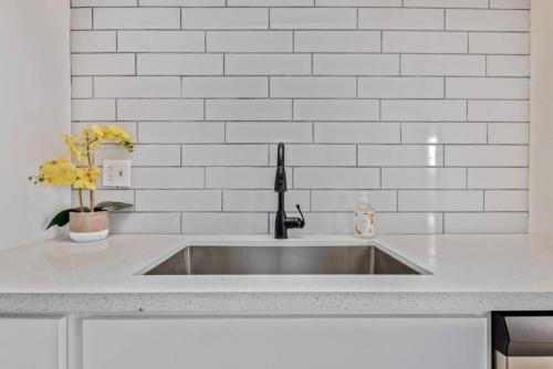 a sink in a kitchen with a white tile wall at Old Town Maya Condo with Community Pool and Spa in Scottsdale