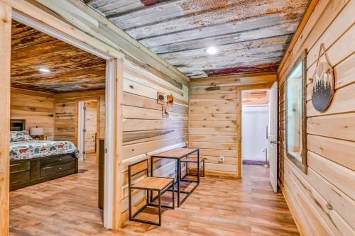 Dormitorio en cabaña de madera con mesa y sillas en Kentucky Cabin Retreat with Covered Porch and Views, en Lewisburg