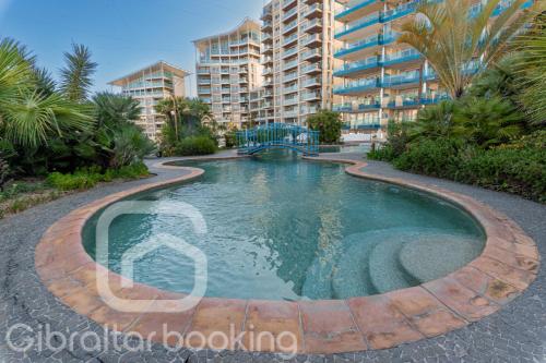 a swimming pool in front of a building at Tropical Paradise at Luxurious Ocean Village in Gibraltar