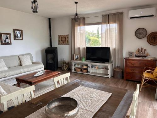 a living room with a couch and a tv at Villa pirastu in Bassacutena