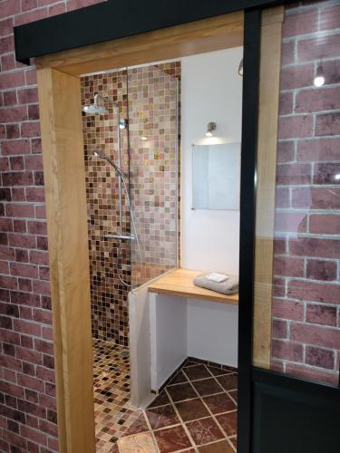 a bathroom with a sink and a shower in a brick wall at Villa au cœur des vignes in Monbazillac