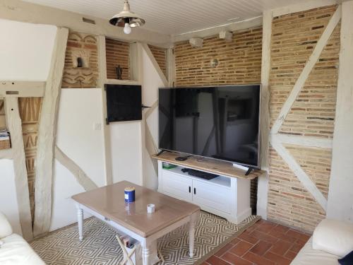 a living room with a flat screen tv on a wall at Villa au cœur des vignes in Monbazillac