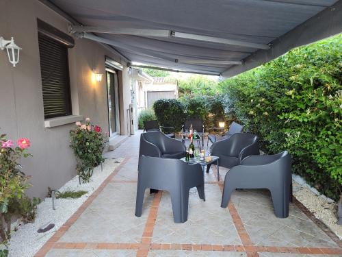 a patio with chairs and a table on a patio at Villa au cœur des vignes in Monbazillac