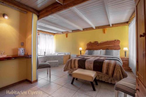 a bedroom with a large bed and a bathroom at Casa Puelo Hostería y Cabañas in Lago Puelo