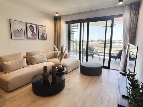 a living room with a couch and a table at Sunset Gardens - Holiday Apartments - by TLV Living in Limassol
