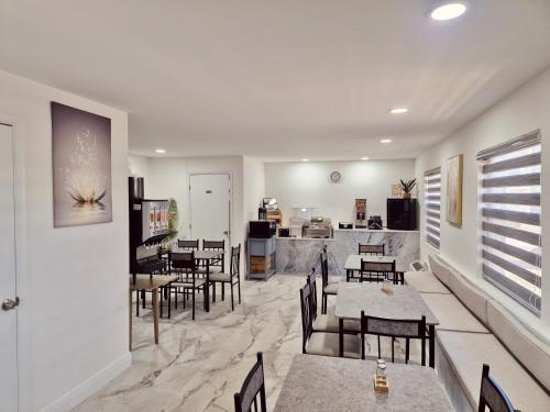 a restaurant with tables and chairs and a kitchen at Nova Inn Resort in Boynton Beach