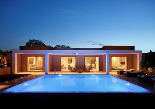 a large swimming pool in front of a house at Ikos Dassia in Dassia