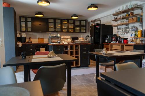 a kitchen with two tables and chairs in a room at The Plantation Faial in Feteira