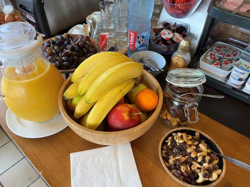 a table with a bowl of fruit and a bottle of orange juice at Hotel Westendia and Free Parking Top Breakfast in Middelkerke
