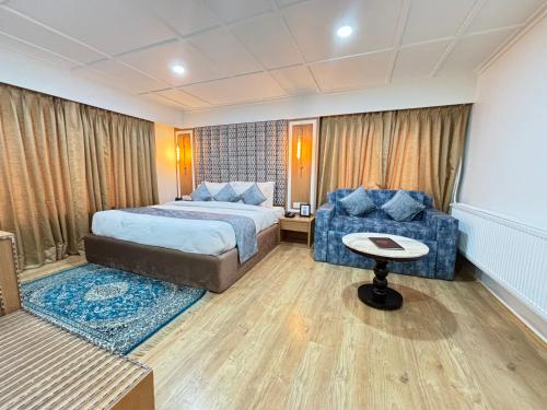 a hotel room with a bed and a chair at Arco Hotels & Resorts sonamarg in Sonāmarg