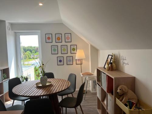 a living room with a table and chairs and a table and a stuffed bear at Grünblick Oase No1 Ferienwohnung Wiesmoor in Wiesmoor