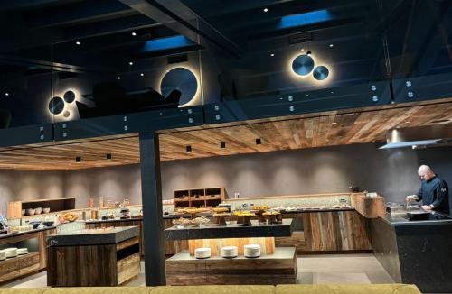 a man is preparing food in a restaurant kitchen at Alpotel Dolomiten in Molveno