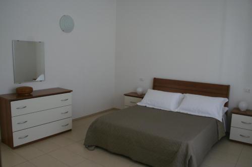 een slaapkamer met een bed, een ladekast en een televisie bij Case VacanzeRò in Ravenna