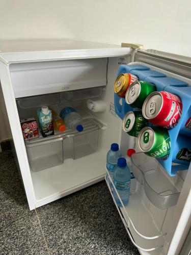 an open refrigerator filled with drinks and soda at Hotel Brasil Real in Mariana
