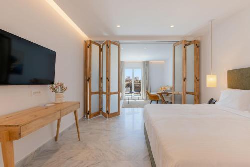 a hotel room with a bed and a flat screen tv at San Antonio Summerland in Mýkonos City