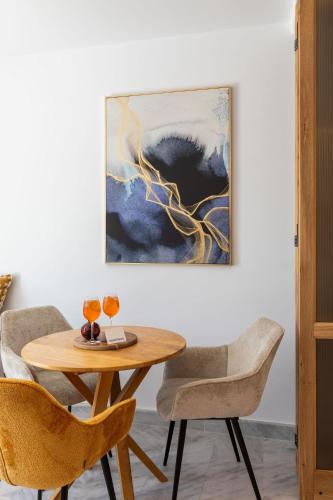 a table and chairs in a room with a painting at San Antonio Summerland in Mýkonos City