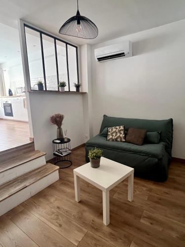 un salon avec un canapé vert et une table dans l'établissement Charmant T2 Centre ville Bastia, à Bastia