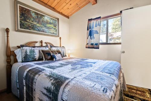 a bedroom with a bed with a blue and white comforter at A Beary Cute Cabin - An adorable cozy cabin nestled in the forest! in Sugarloaf
