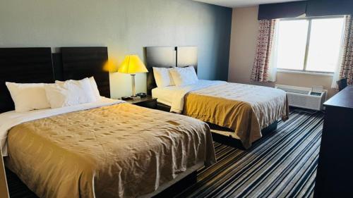 a hotel room with two beds and a window at Wingate by Wyndham Beaver I-15 in Beaver