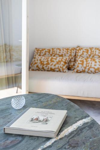 a book on a table in a living room with a couch at San Antonio Summerland in Mýkonos City