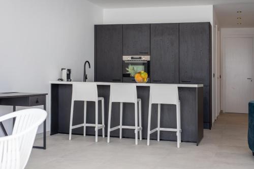 a kitchen with a island with stools and a counter top at Oasis luxury apartment in Jan Thiel - close to the beach in Jan Thiel
