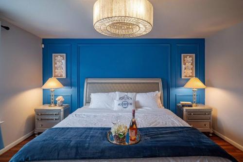 a blue bedroom with a bed with a bottle of wine at Cozy 3 bedrooms House - Feel Like Home in Houston