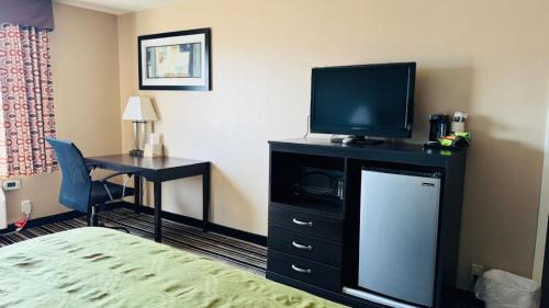 a hotel room with a bed and a television and a desk at Wingate by Wyndham Beaver I-15 in Beaver