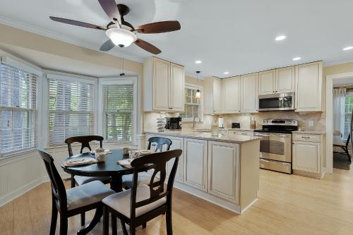 a kitchen with a table and chairs and a ceiling fan at Cozy 4bd Home - NC State & Airport nearby in Cary