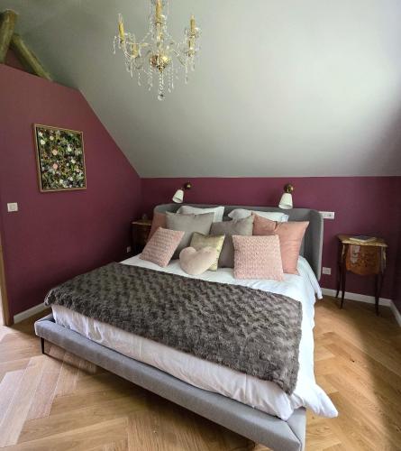 - une chambre avec un lit aux murs violets et un lustre dans l'établissement Villa Trianon Gîte 5 étoiles avec spa privé forêt Villandry, à Villandry