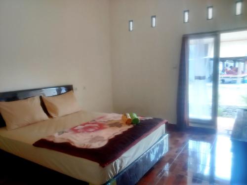 un letto in una stanza con finestra di Rinjani Inn a Sembalun Lawang