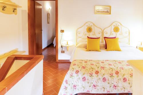 a bedroom with a white bed with yellow pillows at Borgo Il Poggio Agriturismo in Montaione