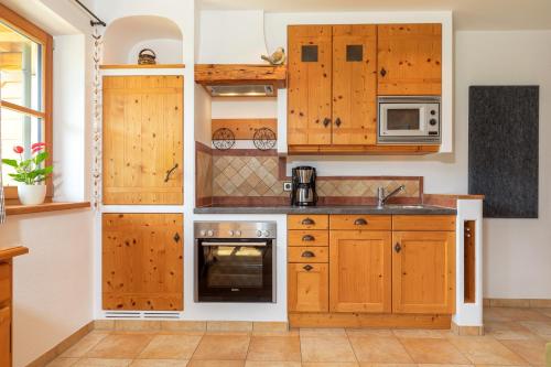 a kitchen with wooden cabinets and a stove at Weber am Gasteig in Reit im Winkl