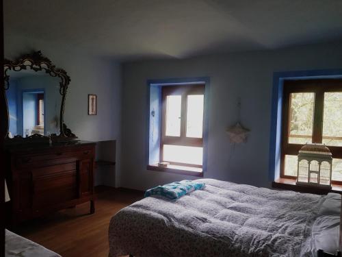 a bedroom with a bed and a dresser and a mirror at B&B La finestra sul bosco in Serralunga di Crea