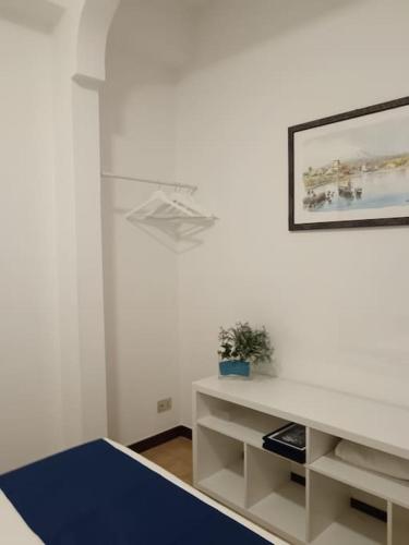 a white room with a table and a picture on the wall at Bilocale a pochi passi dal mare in Giardini Naxos