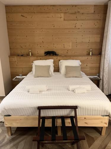a bedroom with a large bed with a wooden wall at Le 19 - Chambre Patio 34m2 - Centre Historique - Clim in Langeac