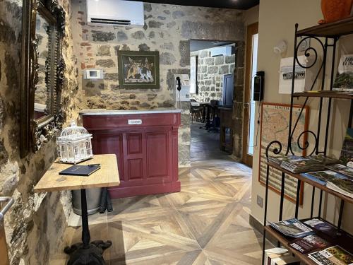 a room with a table and a stone wall at Le 19 - Chambre Patio 34m2 - Centre Historique - Clim in Langeac
