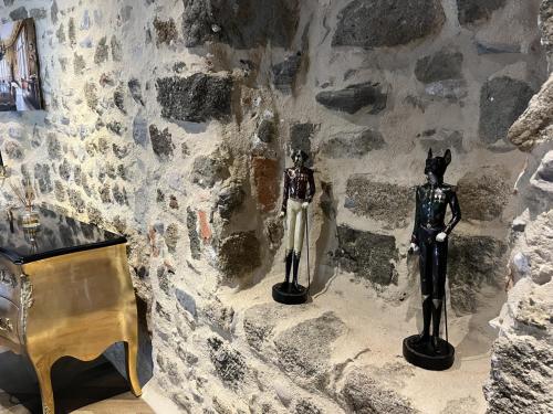 two statues on a stone wall next to a desk at Le 19 Chambre Chapelle 43m2 - Centre Historique - Clim in Langeac