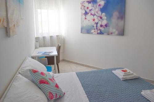 a bedroom with a bed with a blue and white sheets at Targura Lodging in Tarxien