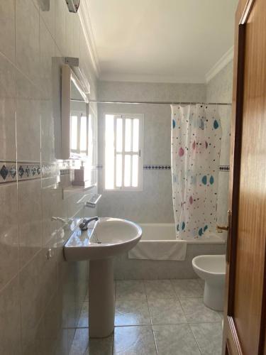 a bathroom with a sink and a tub and a toilet at Pisos Isla Cristina 2 in Isla Cristina